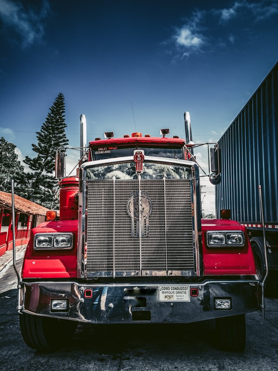 red and white freight truck on snow covered ground during daytime